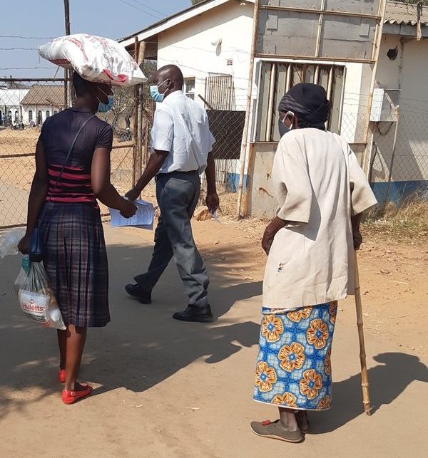 A photo of an older woman patient who is accompanied by a relative and who received a food hamper.